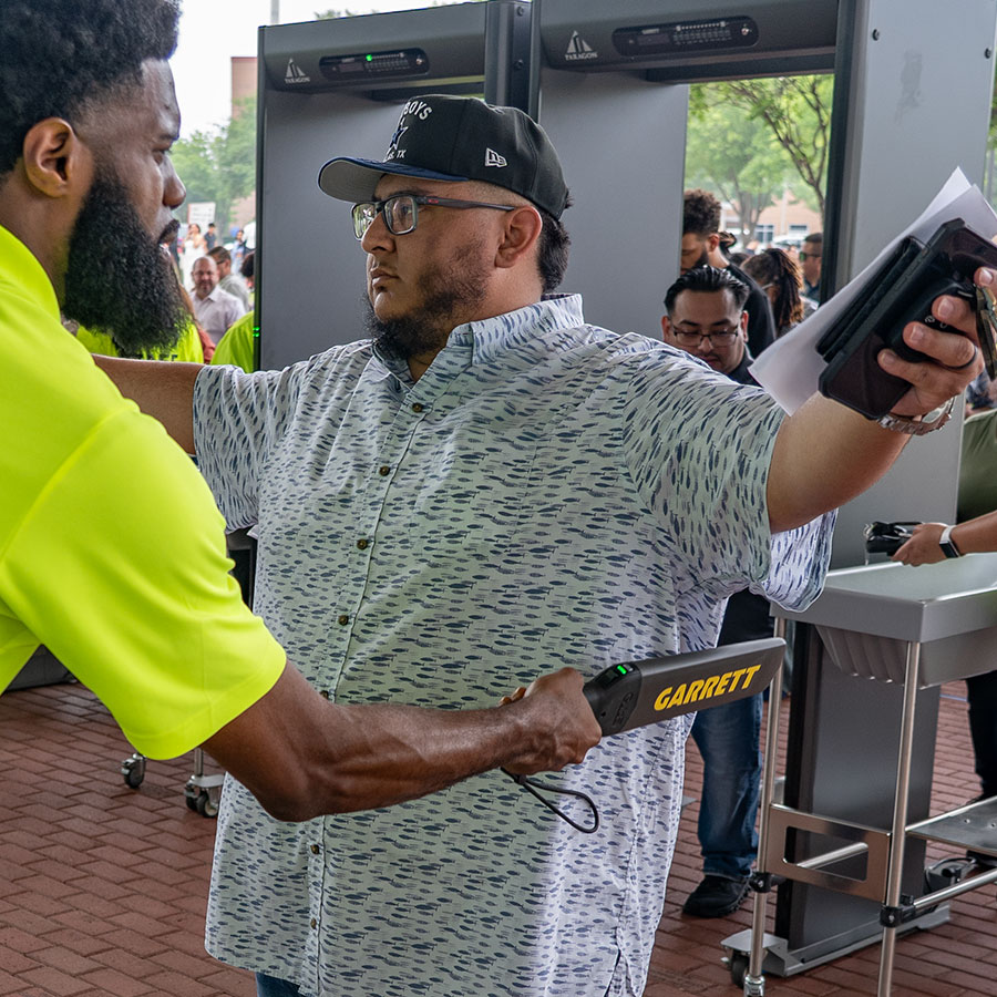 A man being scanned with a Garrett Guide metal detector.
